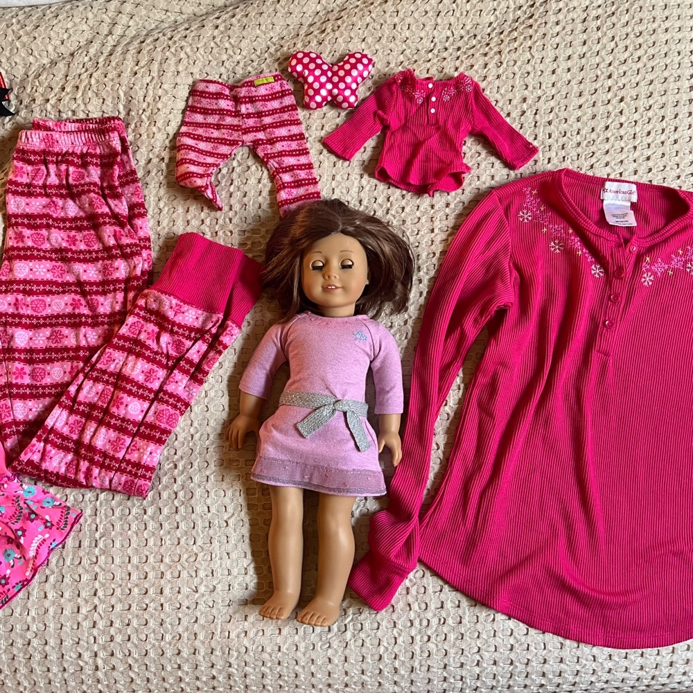 American Girl, with matching pajamas. Brown eyes and short brunette hair.
